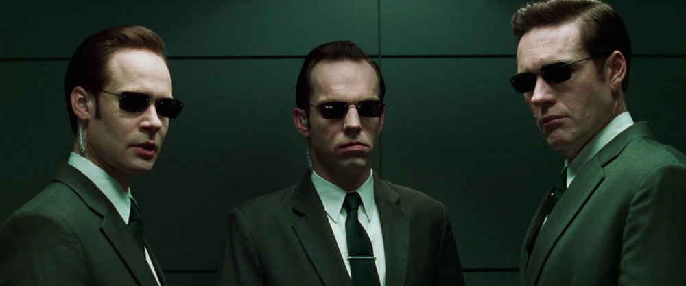 Three agents in suits and sunglasses from the Matrix films